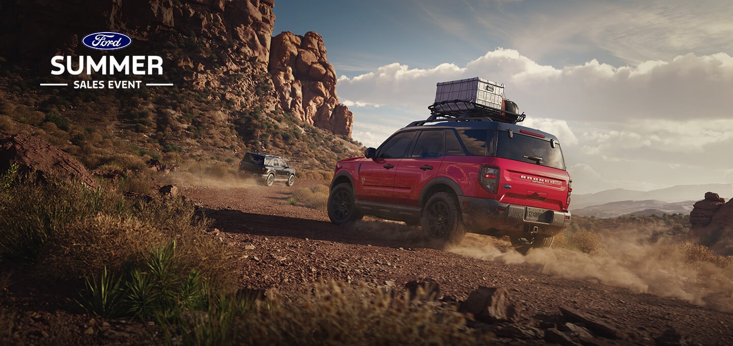 Two Ford Bronco Sport SUVs driving down a desert trail.